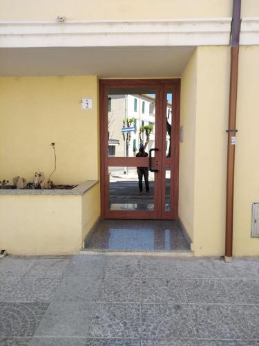 a door to a building with a person standing outside at Clizia Apartment in Alghero