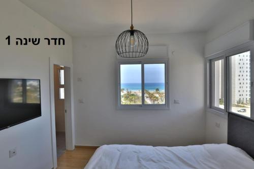 una camera con letto, TV e finestra di דירה בטורקיז a Hadera