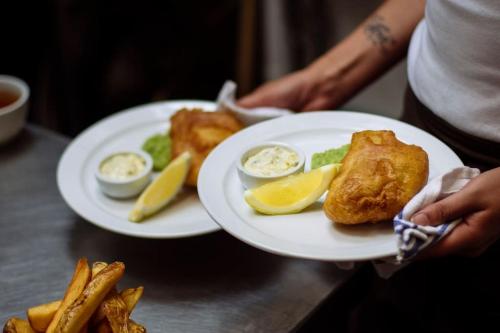 two white plates with food on a table with french fries at The Mexico Inn, Flat One in Ludgvan