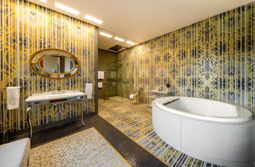 ein Badezimmer mit einer Badewanne und einem Waschbecken in der Unterkunft Harmony Park Hotel & SPA in Prienai