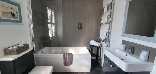 biała łazienka z wanną i umywalką w obiekcie 37 Trinity Lane w mieście Beverley