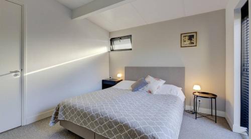 a bedroom with a bed and two tables and two lamps at Olde Kottink in Beuningen