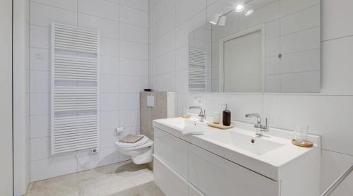 een witte badkamer met een wastafel en een toilet bij Olde Kottink in Beuningen