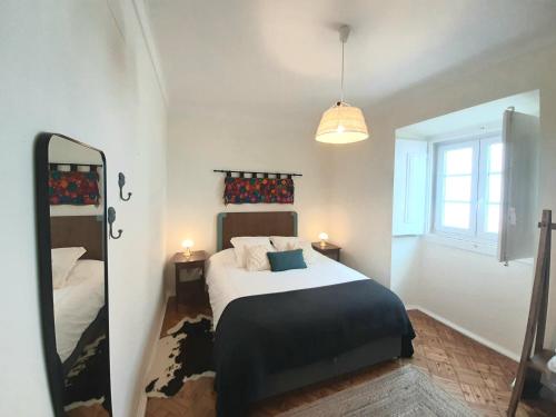 - une chambre avec un lit et un miroir dans l'établissement Do Campo à Praça, à Golegã
