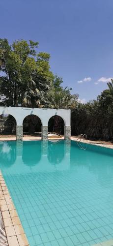 a swimming pool with blue water and a bridge at Ευχάριστη βίλα στη Χαλκίδα στην περιοχή ''Αλυκές'' in Chalkida