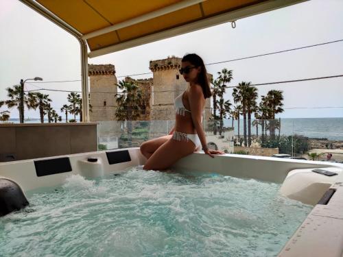 a woman in a bikini sitting in a hot tub at Residenza 4 Colonne CONTEMPORANEA in Santa Maria al Bagno