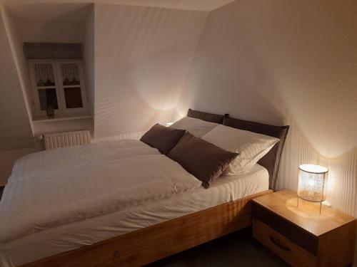 een slaapkamer met een groot wit bed met 2 kussens bij Himmel & Hölle, Heiligegeiststrasse 22 in Quedlinburg