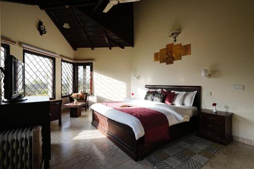 a bedroom with a large bed in a room with windows at Karinya Villas in Nainital