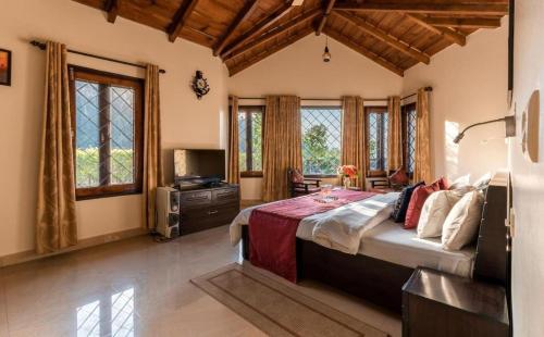 a bedroom with a large bed in a room with windows at Karinya Villas in Nainital
