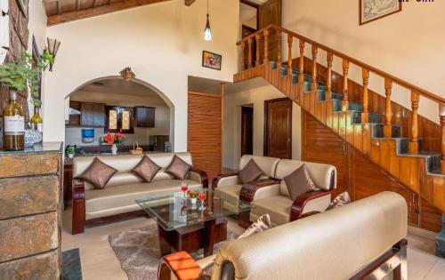 a living room with a couch and a table at Karinya Villas in Nainital