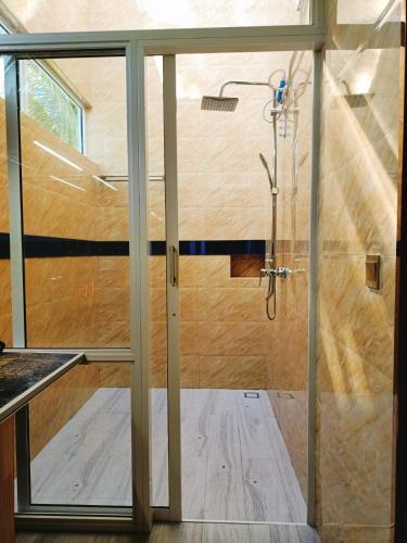 a bathroom with a shower with a glass door at Island Life Maldives Retreat & Spa in Magoodhoo