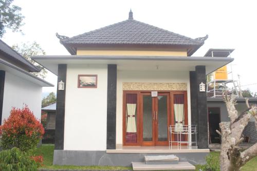 a small white house with a red door at Batur Happy House in Kintamani