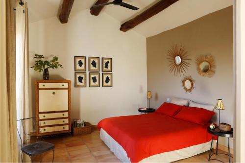 ein Schlafzimmer mit einem roten Bett und einer Kommode in der Unterkunft Villa de 4 chambres avec piscine privee jardin clos et wifi a Beaumes de Venise in Beaumes-de-Venise