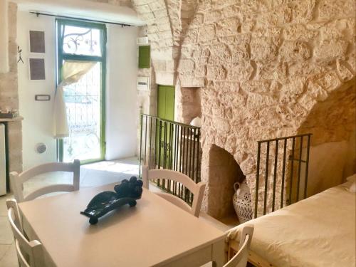 un tavolo in una stanza con un muro in pietra di Il Piccolo Frantoio - Locazione Turistica a Ostuni