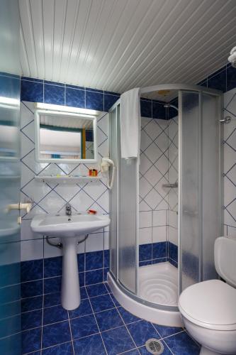 a bathroom with a shower and a sink and a toilet at Latania Apartments in Stalida