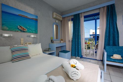 a bedroom with a bed with a towel animal on it at Latania Apartments in Stalida