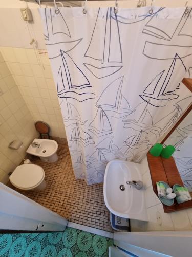 ein Badezimmer mit Waschbecken, Toilette und Duschvorhang in der Unterkunft Albergo Stella Di Mare in Lavagna