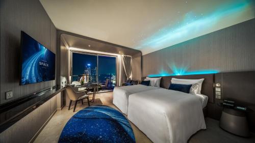 a hotel room with a large bed and a window at Grande Centre Point Space Pattaya in Pattaya North