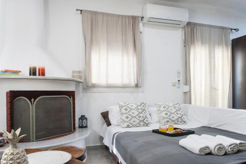 a living room with a couch and a tv at Bohemian Townhouse in Skiathos Town