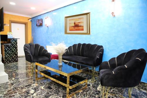 a salon with black chairs and a blue wall at LAOS OTEL in Istanbul