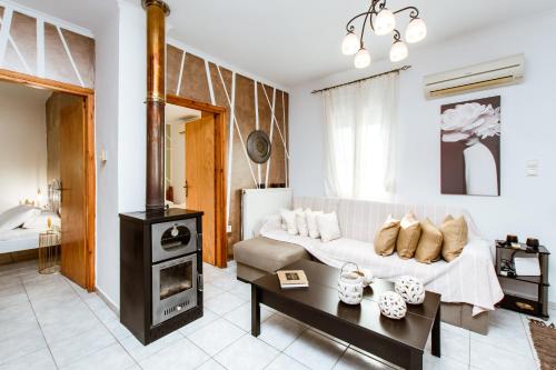 a living room with a white couch and a stove at Villa Archontiki I - Private Pool in Vryses