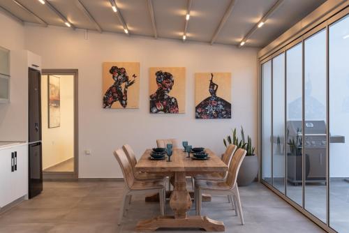 a dining room with a wooden table and chairs at Margaret Villa - Pool, Heated Spa Whirlpool & BBQ, By ThinkVilla in Angeliana