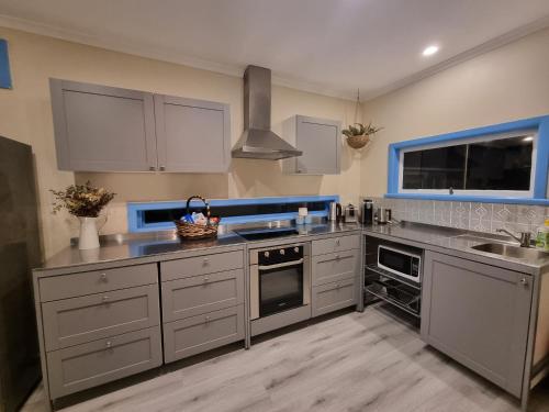a kitchen with stainless steel appliances and blue accents at Vitamin Sea Beach House with outdoor Spa in Rosebud