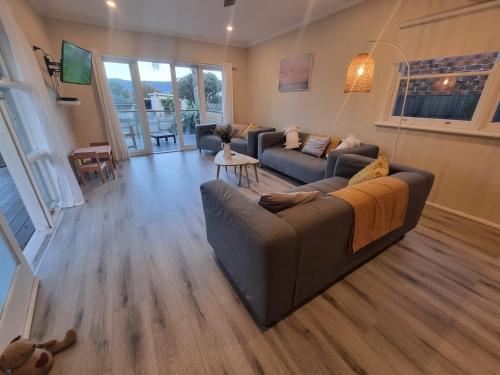 a living room with a couch and a table at Vitamin Sea Beach House with outdoor Spa in Rosebud