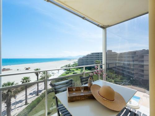 a balcony with a table and a view of the beach at Apartment Le Beach-24 by Interhome in Canet-en-Roussillon