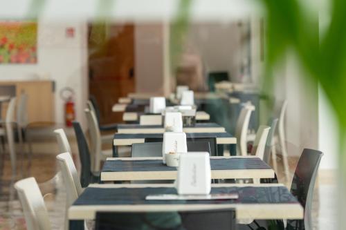 a row of tables and chairs in a cafeteria at Hotel Auditorium in Bari