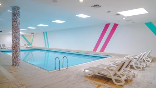 a swimming pool with lounge chairs in a building at Barut B Suites in Side