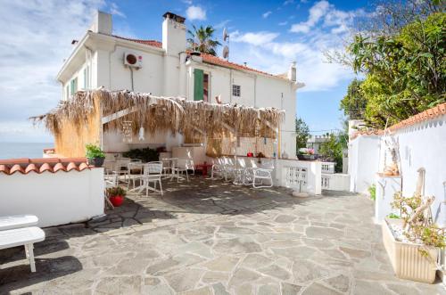 a white house with a patio with tables and chairs at Hotel Villa La Brise in Sanremo