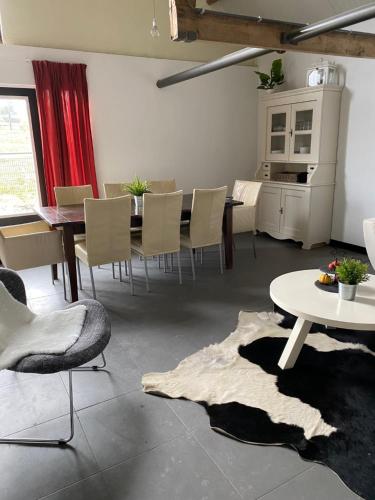 uma sala de jantar com mesa e cadeiras em Herberg Boerderij de Straat-Hof em Leimuiden
