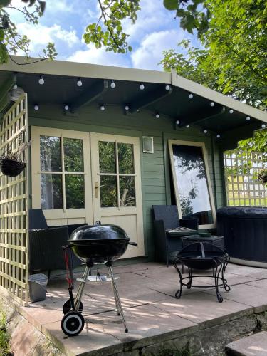 a grill on a patio in front of a house at Ty Bach Twt, Coity Bach in Brecon