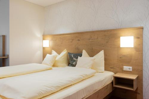 a bedroom with a large bed with white pillows at DEVA Hotel Renchtalblick in Oberkirch