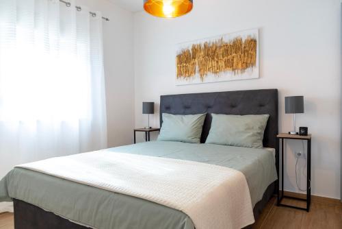 a bedroom with a large bed with two night stands at Apartmani Sara in Bibinje