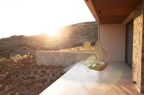 a bench on the side of a building with the sunset at Nuez Villas in Mochlos