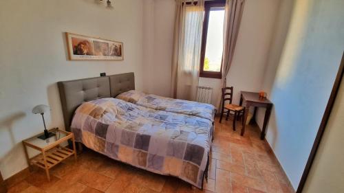 um quarto com uma cama, uma mesa e uma janela em Stanza con due letti singoli Le Vitterelle em Zocca
