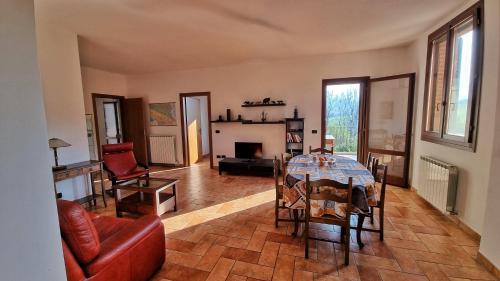 sala de estar con mesa y chimenea en Stanza con due letti singoli Le Vitterelle, en Zocca