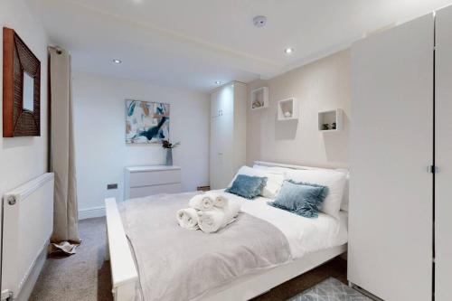 a bedroom with a white bed with stuffed animals on it at Lovely 2 Bedroom Apartment near Highgate Station in London