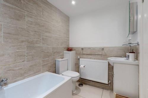 La salle de bains est pourvue de toilettes blanches et d'un lavabo. dans l'établissement Lovely 2 Bedroom Apartment near Highgate Station, à Londres