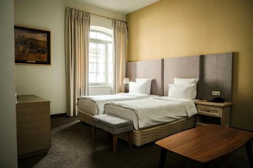 Rúm í herbergi á GRAND HOTEL GYUMRI by APRICOT Hotels