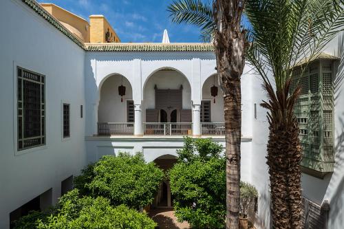 una casa blanca con una palmera delante de ella en Riad Talaa12, en Marrakech