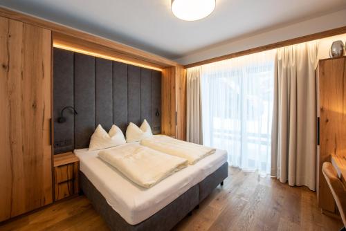 a bedroom with a large bed and a large window at Chalet Hochkrimml 43 in Krimml