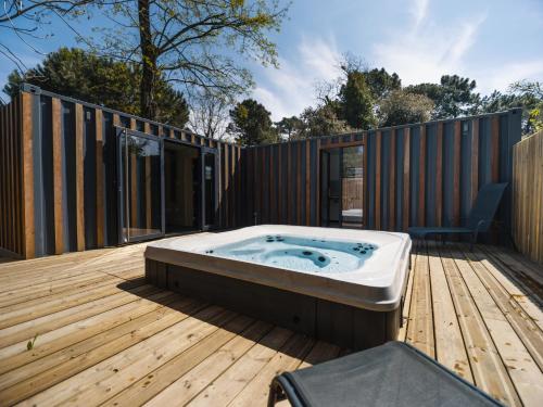 une baignoire jacuzzi assise sur une terrasse en bois dans l'établissement Camping 3 étoiles Les Fougères, à Rivedoux-Plage