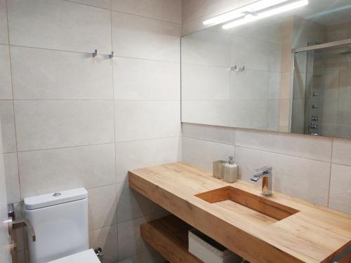 a bathroom with a wooden sink and a mirror at Duplex Premium Peñiscola Playa Orangecosta in Peñíscola