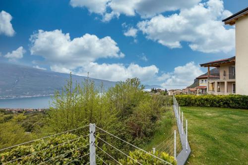 a view of a house from a yard with a fence at Residence La Villa Fewo Cristallo in Tignale