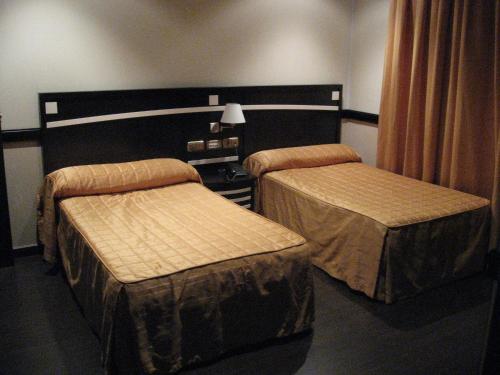 two beds in a hotel room withskirts at Hotel Machaco in Alburquerque