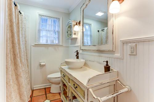 a bathroom with a sink and a toilet and a mirror at Ocean Ave Seaside Cottage in Fernandina Beach