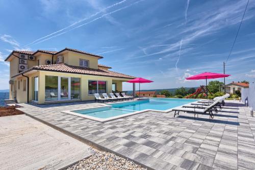 Gorica的住宿－Villa Karli，别墅 - 带带椅子和遮阳伞的游泳池